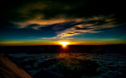 地平線から太陽が出る瞬間の山頂から撮影した写真