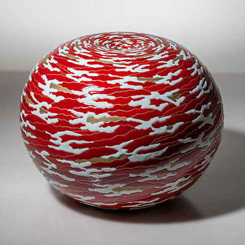 赤地に白い紋様の丸い陶芸作品