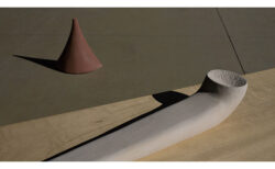 焦茶の三角錐とパイプガキの板に載っている静物画