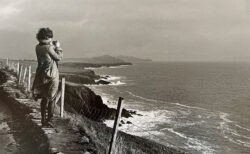 アイルランドの断崖に立つ女性のモノクロ写真