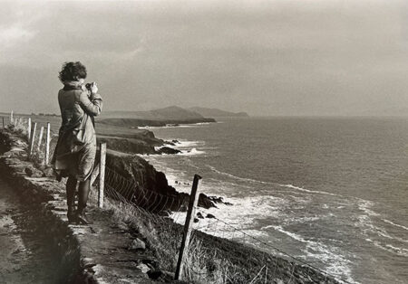 アイルランドの断崖に立つ女性のモノクロ写真